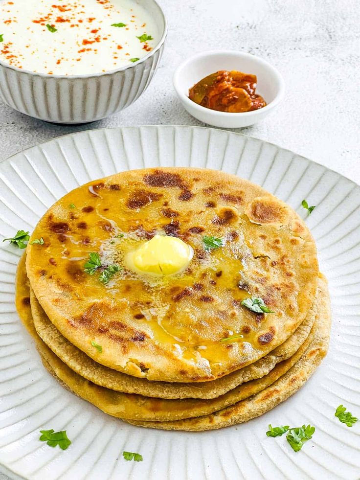 Freshly cooked aloo paratha served with butter and pickle