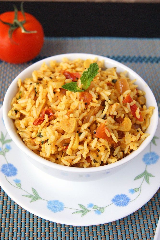 Bowl of homemade tomato rice garnished with fresh herbs